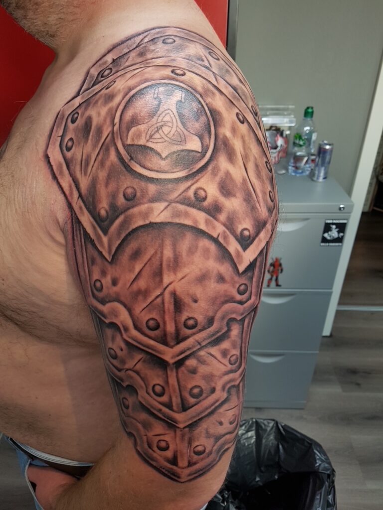 Detailreiches Tattoo eines Wikinger-Schildes auf dem Oberarm. Tattoo in Hamburg von Ozzy gestochen