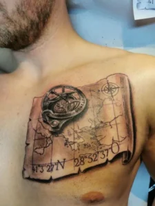 Tattoo eines alten Kartenabschnitts mit Kompass auf der Brust . Tattoo in Hamburg von Ozzy gestochen