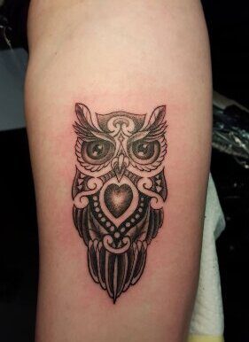 Eine ornamentale Eule mit einem Herz und Mandala-Mustern als Blackwork-Tattoo. Eulen-Tattoo von Ozzy in Hamburg gestochen.